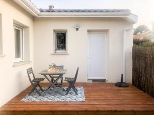 a patio with a table and chairs on a deck at Studio Nathalie et Sebastien in La Brede
