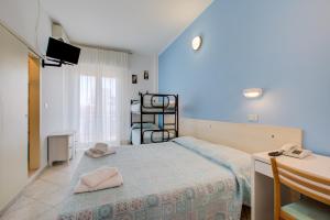 a bedroom with a bed and a desk and a television at Hotel Sant'Angelo in Riccione