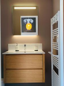 a bathroom with a sink with a picture of an orange at Warm & Wood in Clermont-Ferrand