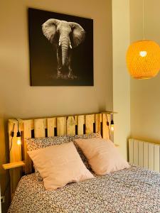 a bedroom with an elephant picture on the wall at Warm & Wood in Clermont-Ferrand