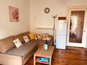 a living room with a couch and a refrigerator at Drumdryan Apartment Edinburgh in Edinburgh