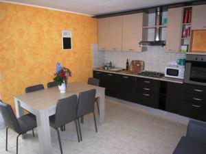 a kitchen with a table and chairs and a kitchen with yellow walls at Casa Mary in San Siro