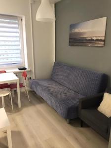 um sofá num quarto com uma mesa e uma janela em Chopin apartments self check-in em Varsóvia