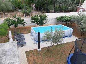 a large swimming pool with chairs and trees at Apartment Ante in Bibinje