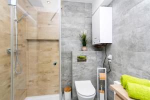 een badkamer met een douche, een toilet en een wastafel bij Apartament nad morzem. Gdańsk Wyspa Sobieszewska in Gdańsk