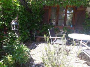 eine Terrasse mit einem Tisch und Stühlen im Garten in der Unterkunft Schweizerblick in Hänner