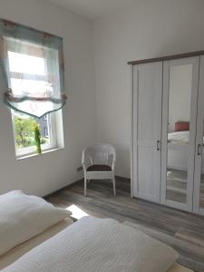 una camera con letto, specchio e sedia di Ferienwohnung Leilas Lodge a Langelsheim