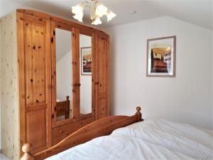 1 dormitorio con armario de madera y cama en Sonnenblume, en Heidesee