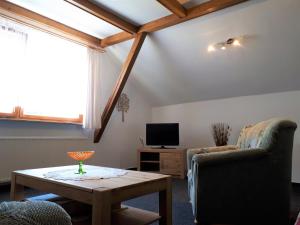 a living room with a table and two chairs and a tv at Sonnenblume in Heidesee