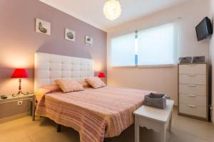 ein Schlafzimmer mit großem Bett und Fenster in der Unterkunft Apartamento sobre a praia in Olhos de Água + 17 Fotos