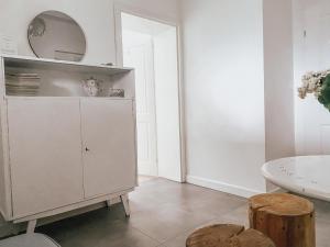 a white kitchen with a mirror on top of a cabinet at Apartamenty Rajcza in Rajcza +65 photos