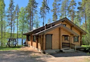 a log cabin in the woods next to a lake at Lappalaisen lomamökit Norpparanta in Puumala