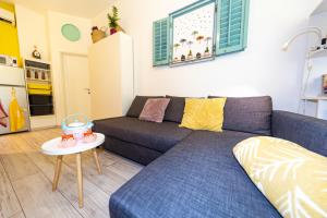 a living room with a blue couch and a table at Studio Apartman Baronessa Adriana in Rijeka