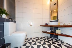 a bathroom with a toilet and a black and white checkered floor at Studio Apartman Baronessa Adriana in Rijeka