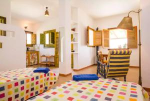 a bedroom with two beds and a chair and a table at La Atalaya del Río Seco in Almuñécar