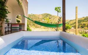 a swimming pool with a hammock in a house at La Atalaya del Río Seco in Almuñécar