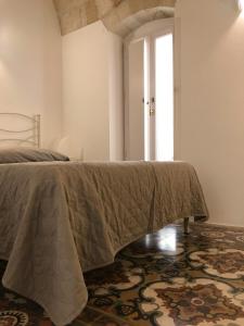 um quarto com uma cama com um cobertor em B&B Casa Dorsi em Polignano a Mare