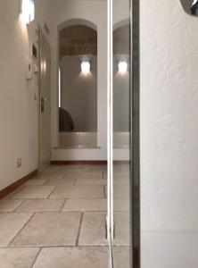 pasillo con espejo y suelo de baldosa en B&B Casa Dorsi, en Polignano a Mare