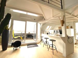 una sala de estar con una mesa y taburetes en LA CLE DES TOITS, en Colmar