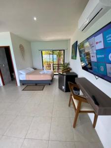 a large room with a bed and a flat screen tv at Cuxos Hotel Beachfront in Isla Mujeres