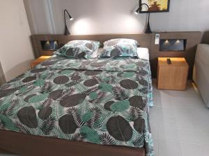 ein Schlafzimmer mit einem Bett mit einer grünen und braunen Bettdecke in der Unterkunft Sea Sun Manga in Saint-François