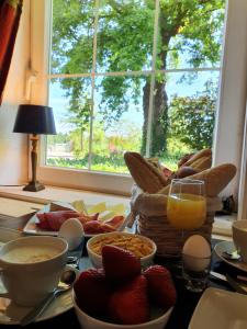 Klimmen的住宿－Boutique Hotel Villa de Proosdij，一张早餐桌,早餐食品和窗户