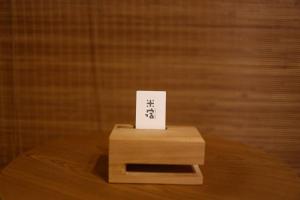 una caja de madera con un cartel en la parte superior de una mesa en 米宿 Roomi House 台南老屋民宿 en Tainan