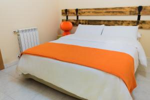 a bedroom with a large bed with an orange blanket at La Cueva de Villahormes in Villahormes