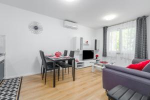 a living room with a table and a couch at Apartman POREČ CENTER SEA in Poreč