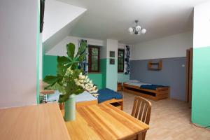 a living room with a table and a room with two beds at Szumilas miejsce spotkań in Bydgoszcz