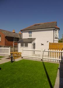 a white fence in front of a white house at Carriers Cottage, Isle of Wight in Shanklin