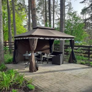 ein Zelt mit Tisch und Stühlen in einem Garten in der Unterkunft Zīlīšu holiday house in Jūrmala
