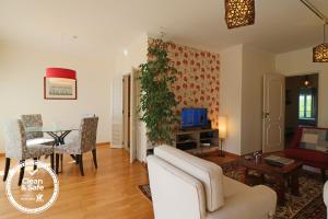 uma sala de estar com um sofá branco e uma mesa em Cascais Estoril Apartment 400 m from Beach em Estoril