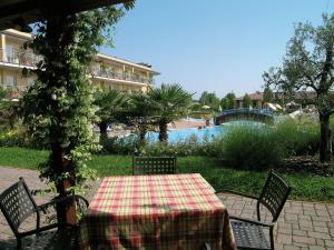 a table with a checkered table cloth sitting in a garden at Camping Bella Italia in Peschiera del Garda