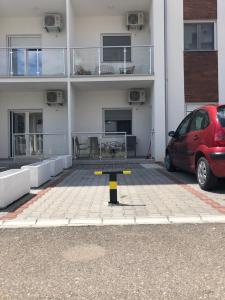 巴尼亚科维利亚查Apartman Jezdić 2的大楼前带长凳的停车场