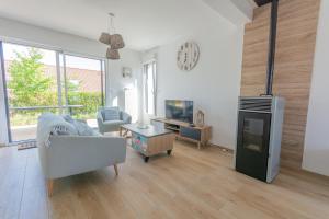 a living room with a couch and a tv at Villa Bellevue in Ambleteuse