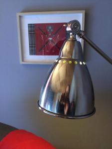 a silver lamp with a picture of a clock on a wall at La Marténie in Mijoux