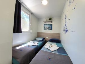 Mobile home BLUE CLASS B4 tesisinde bir odada yatak veya yataklar