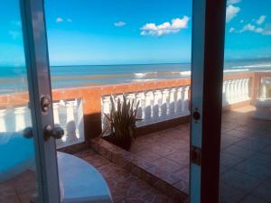 eine Tür zu einem Balkon mit Meerblick in der Unterkunft Hotel Colombus in Aguada