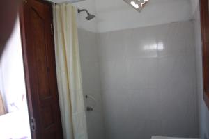 a bathroom with a shower with a shower curtain at Sony Home Stay in Amed
