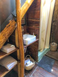 a bathroom with a sink and a shelf with towels at Tunich Jungle Cabañas in Tulum