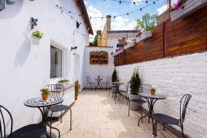 a patio with tables and chairs on a building at Penzion Mácha in Litoměřice