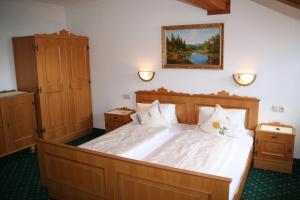 una camera da letto con un letto grande con lenzuola bianche di Alpengasthof Rechtegg a Neukirchen am Grossvenediger