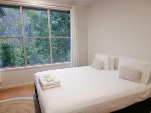 a white bed in a room with a large window at Stay @ LP Montville in Montville