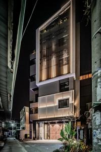 wysoki budynek w nocy z włączonymi światłami w obiekcie Hotel Leisure 台南行旅-巷弄潮旅 w mieście Tainan