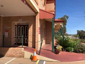 un edificio de ladrillo con un cono naranja delante de él en Heritage Motor Inn Goulburn, en Goulburn