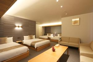 Habitación de hotel con 2 camas y sofá en GRAND BASE Nagoya Ekinishi, en Nagoya