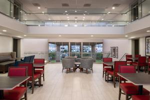 a dining room with tables and chairs and windows at Holiday Inn Express San Francisco Airport South by IHG in Burlingame