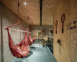 a room with two hammocks hanging from a wall at Oinn Hotel & Hostel Tainan in Tainan