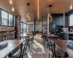 a restaurant with wooden tables and chairs and windows at Oinn Hotel & Hostel Tainan in Tainan